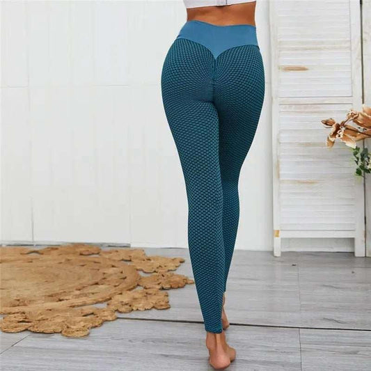 Woman wearing blue high waist textured workout leggings indoors