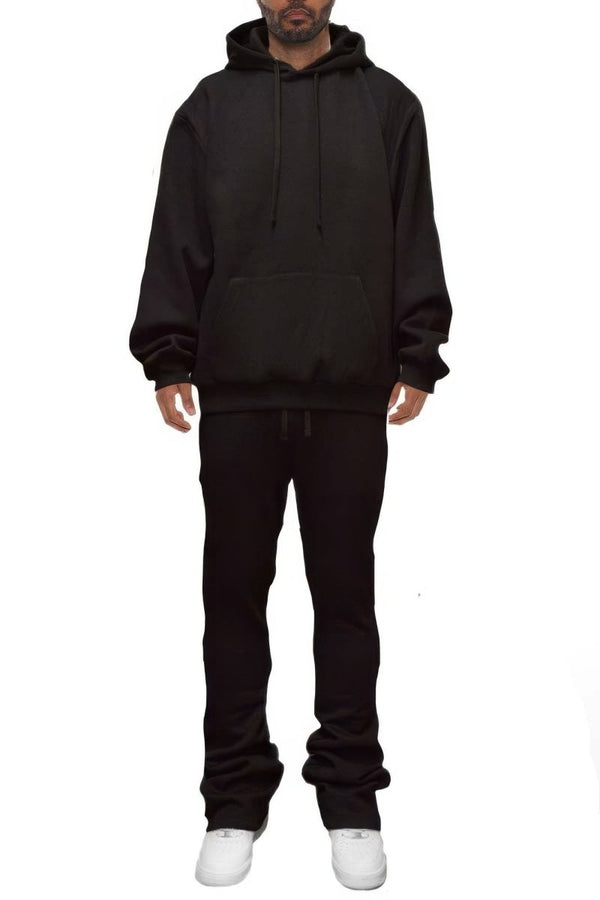 Person wearing a black hoodie and pants on a white background