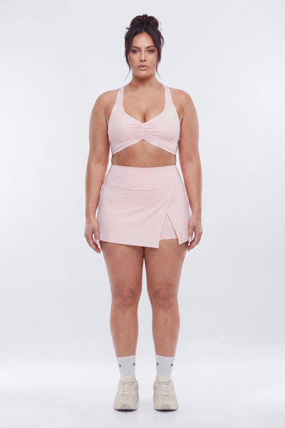 Woman wearing a pink athletic outfit on a white background