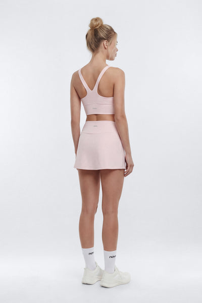 Woman wearing a pink athletic outfit on a white background