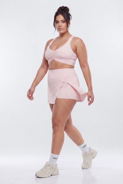Woman wearing a pink athletic outfit on a white background