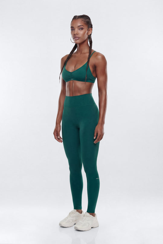 Woman wearing a green athletic outfit on a white background