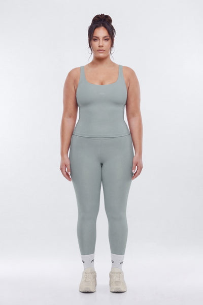 Woman wearing a gray athletic outfit on a white background