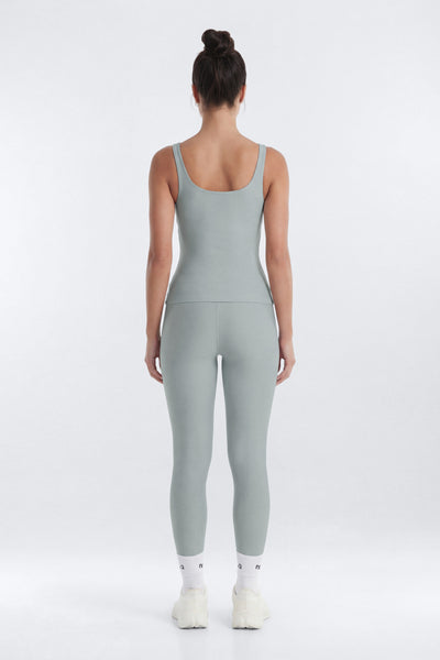 Person wearing a light gray jumpsuit on a white background
