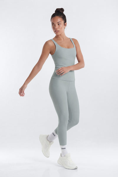 Woman wearing a gray athletic outfit on a white background