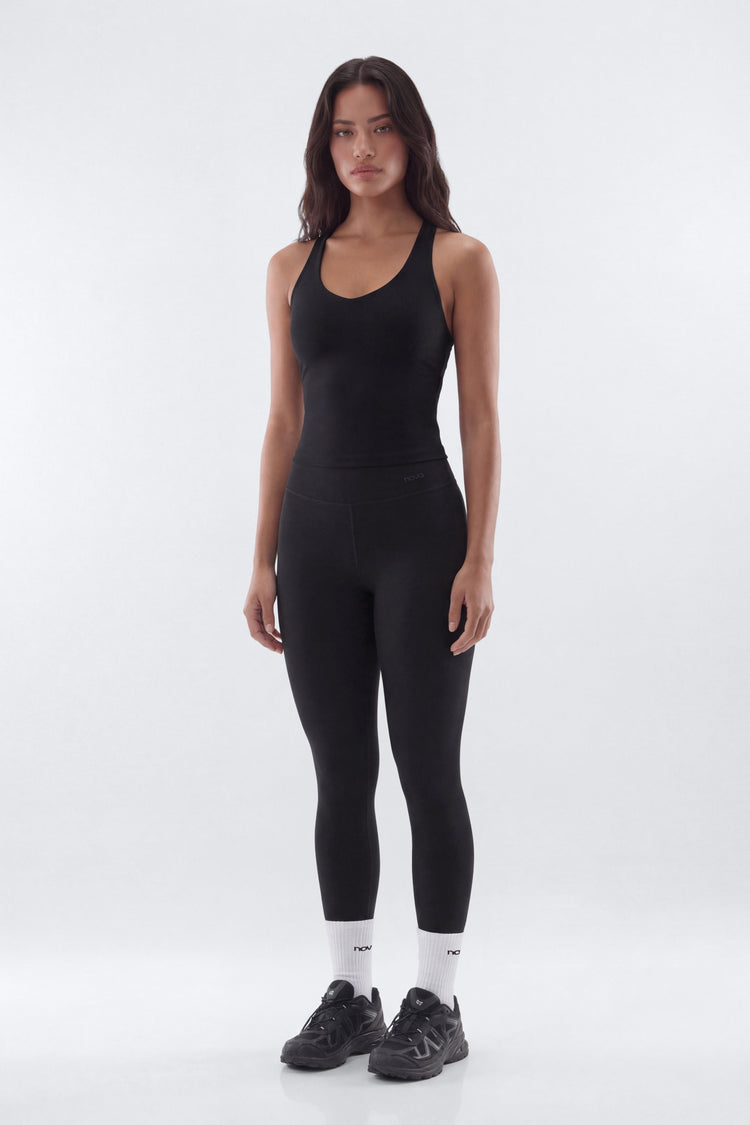Woman wearing a black athletic outfit on a white background