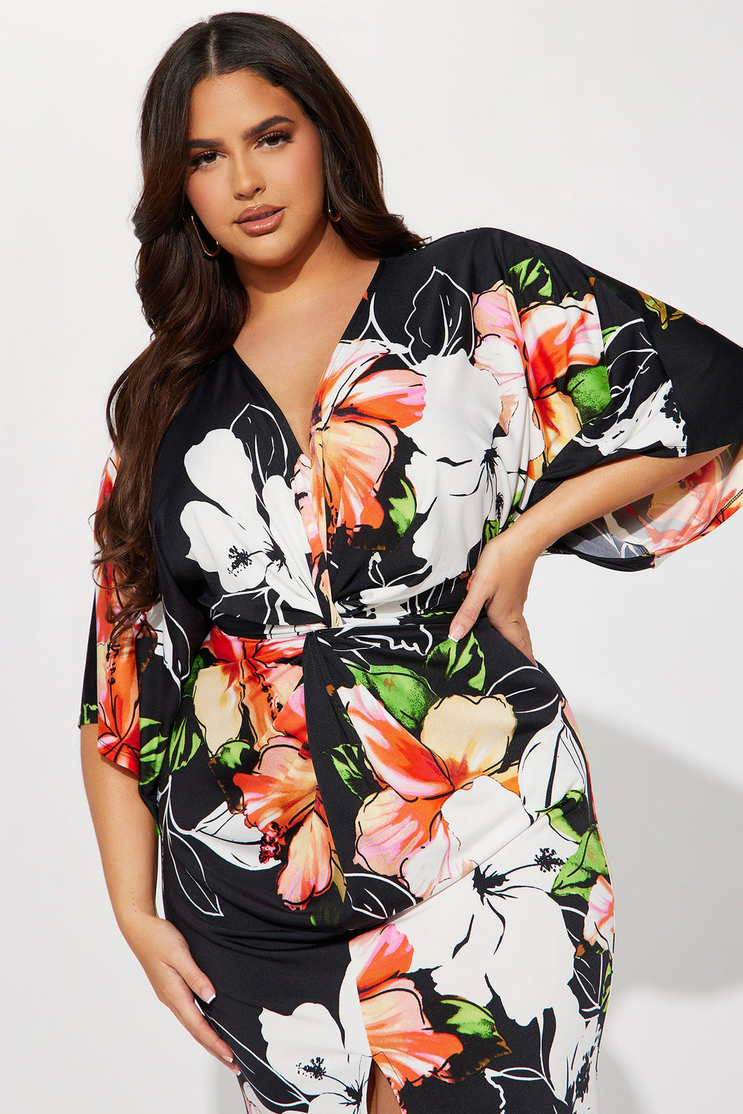 Woman wearing a black floral dress with colorful flowers on a white background