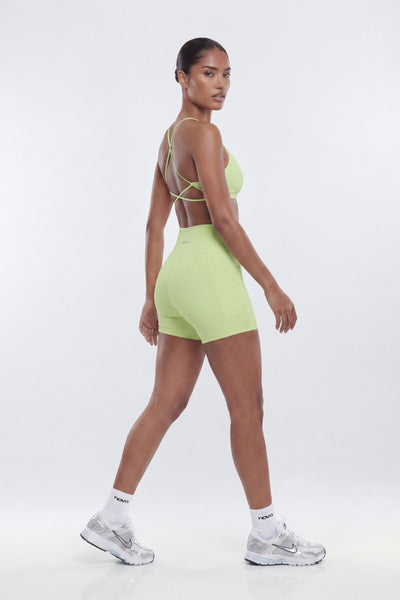 Woman wearing a light green sports outfit on a white background