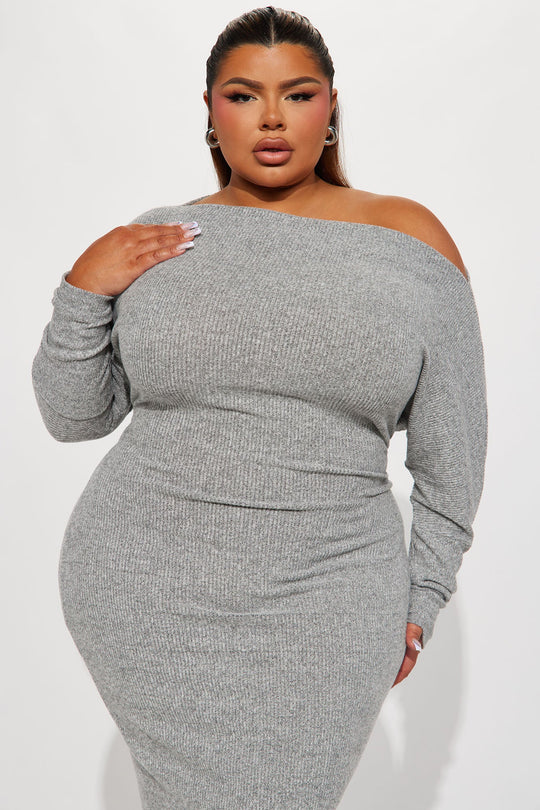 Woman wearing a gray off-shoulder ribbed dress on a white background