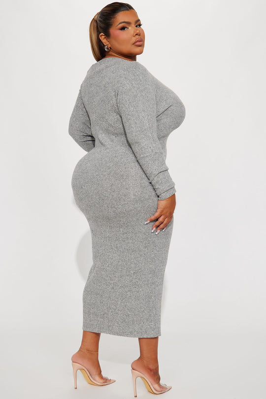 Woman wearing a gray knit dress against a white background
