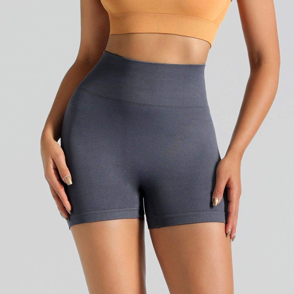 Person wearing dark gray high-waisted shorts on a light gray background