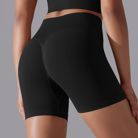 Black athletic shorts worn by a person on a gray background