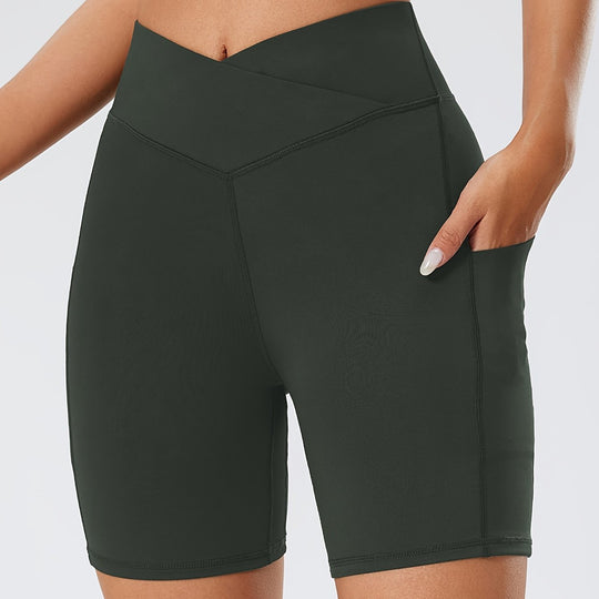 Dark green athletic shorts worn by a person on a light gray background