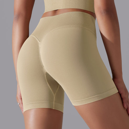 Beige athletic shorts worn by a person on a gray background