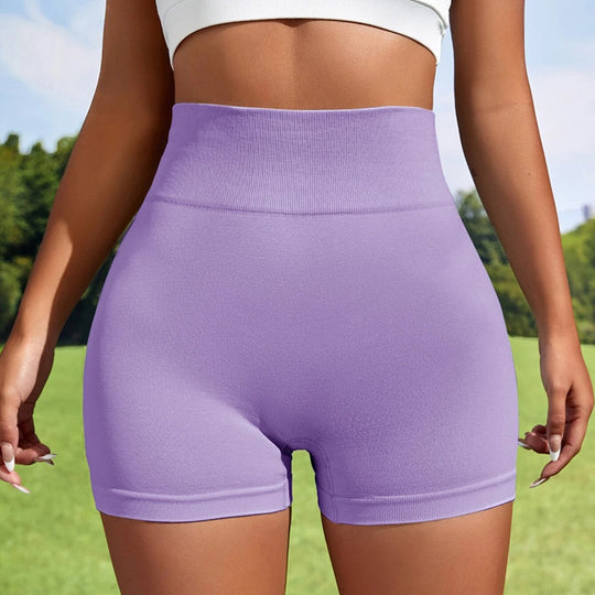Person wearing purple high-waisted shorts with a blurred green outdoor background