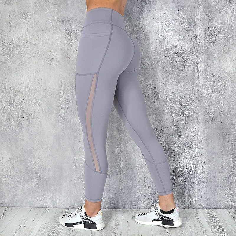 a woman in grey leggings with a white top