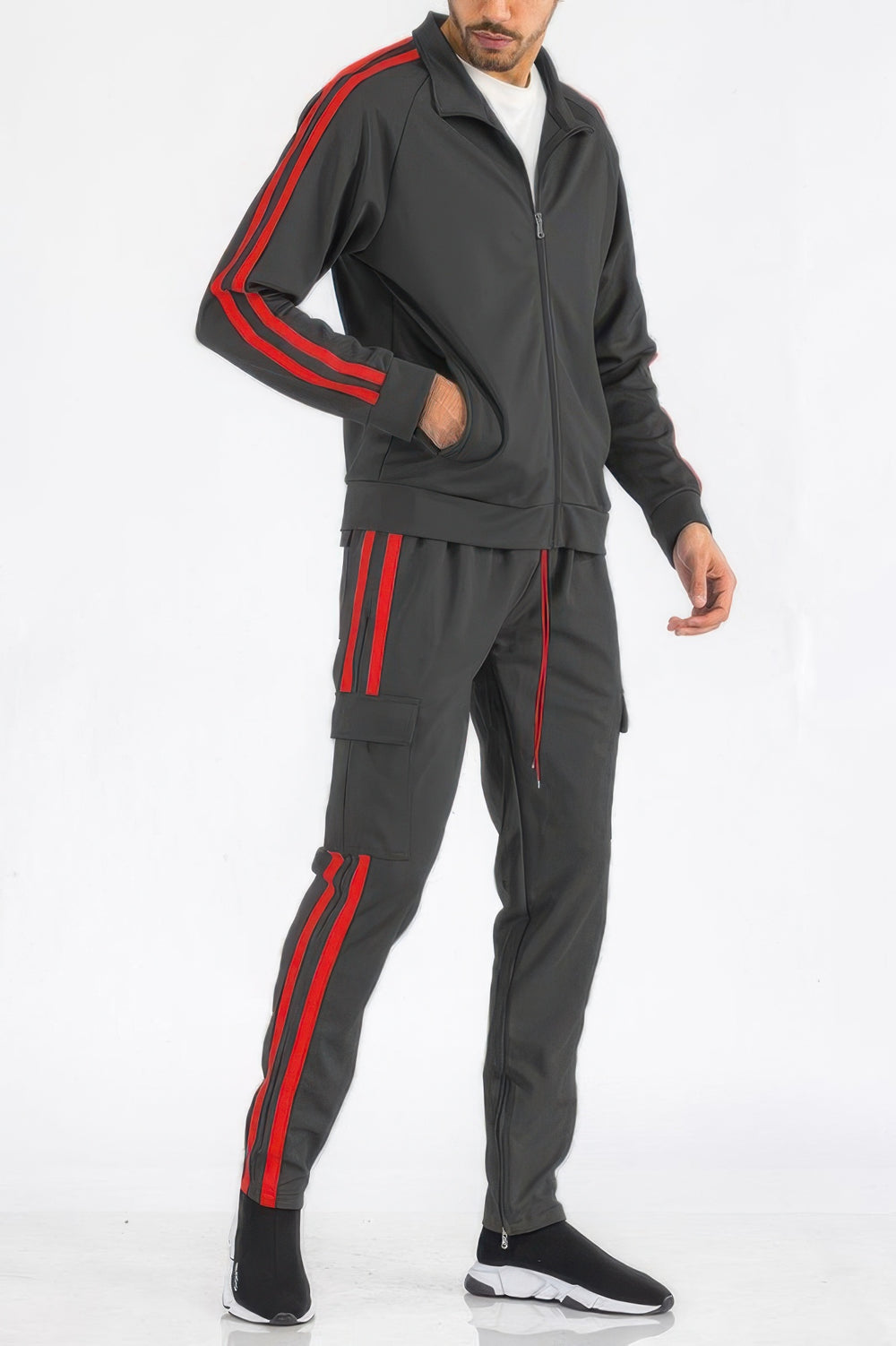 Man wearing a gray tracksuit with red stripes on a white background