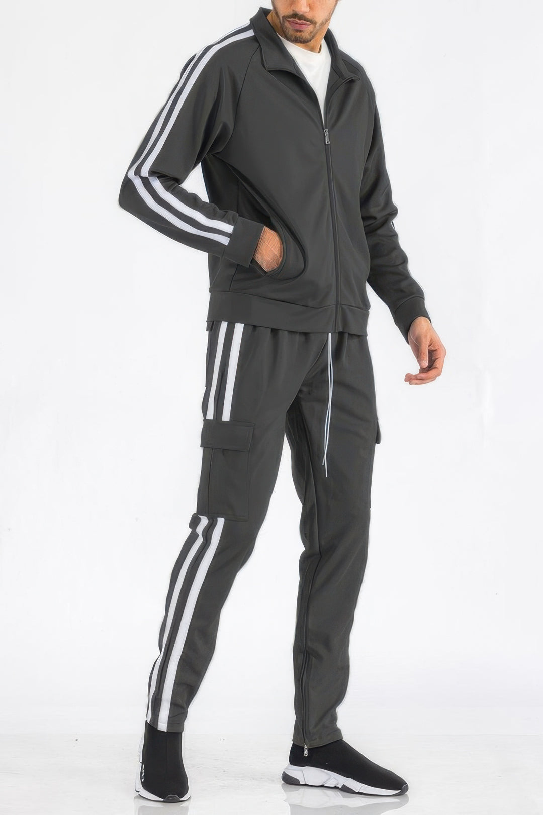 Man wearing a gray tracksuit with white stripes on a white background
