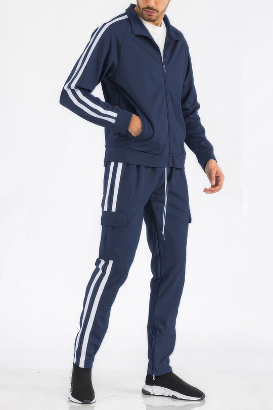 Person wearing a navy tracksuit with white stripes on a white background