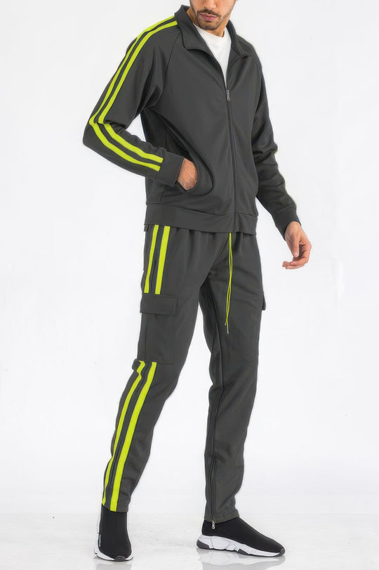 Man wearing a gray tracksuit with yellow stripes on a white background