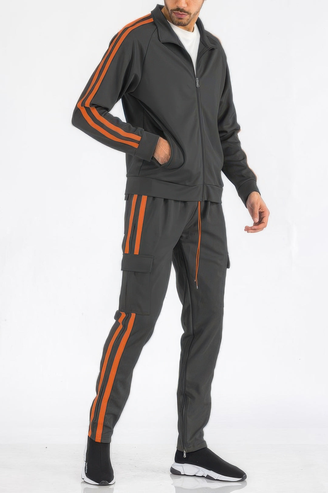 Man wearing a gray tracksuit with orange stripes on a white background