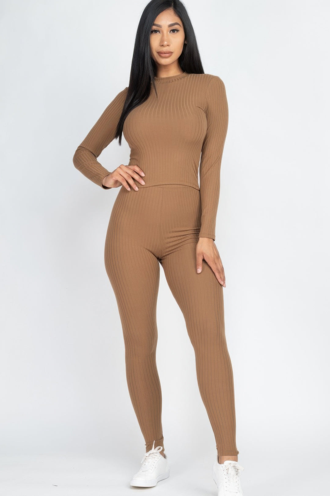 Woman wearing a brown ribbed outfit on a white background
