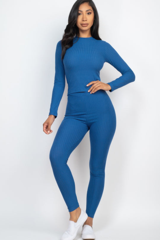 Woman wearing a blue ribbed outfit on a white background