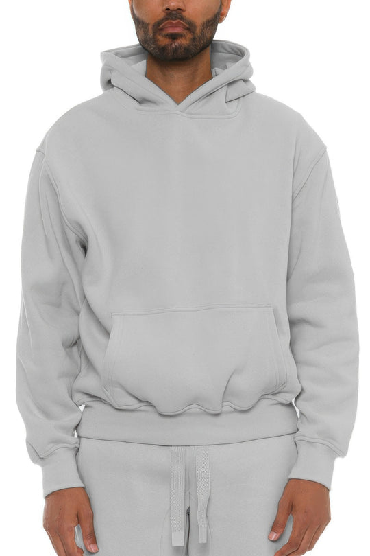 Man wearing a gray hoodie and pants on a white background