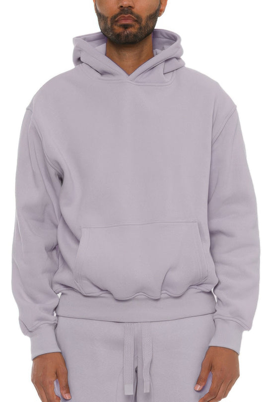Man wearing a light purple hoodie and pants on a white background