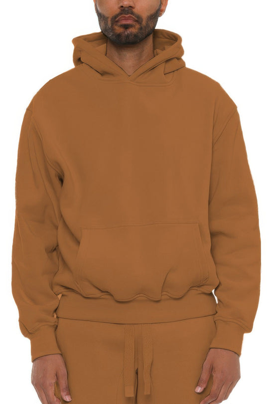 Man wearing a brown hoodie and pants on a white background