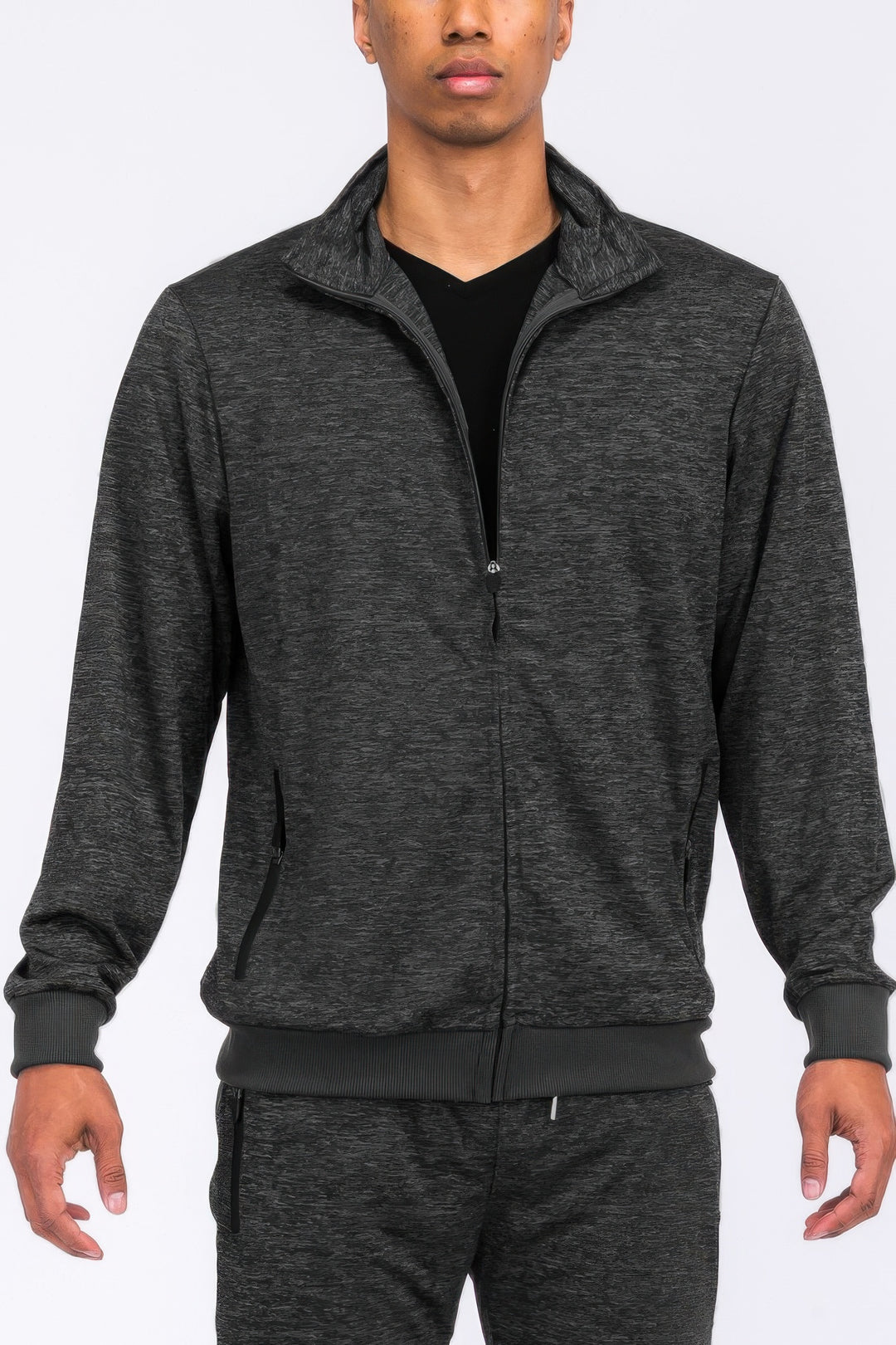 Person wearing a gray tracksuit on a white background