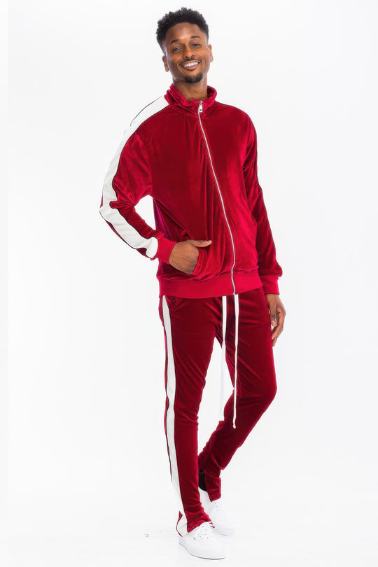 Man wearing a red tracksuit with white stripes on a white background