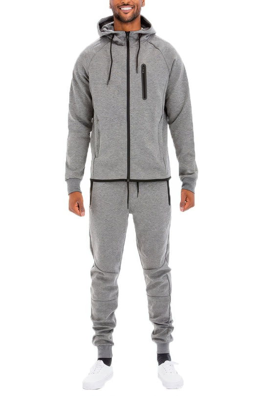 Man wearing a gray tracksuit on a white background
