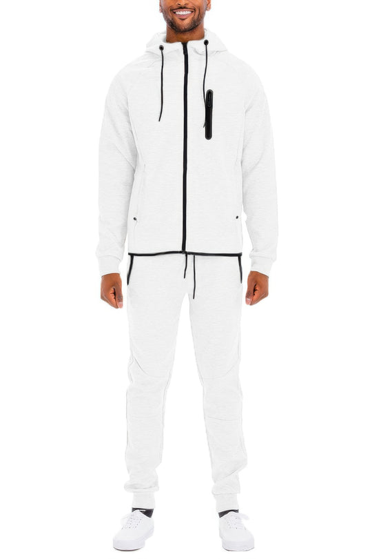 Man wearing a white tracksuit with black accents on a white background