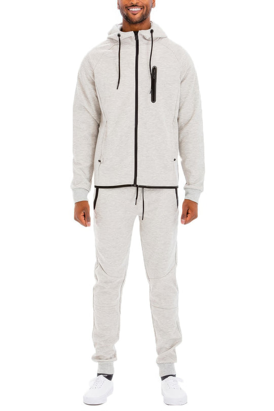 Man wearing a gray tracksuit on a white background
