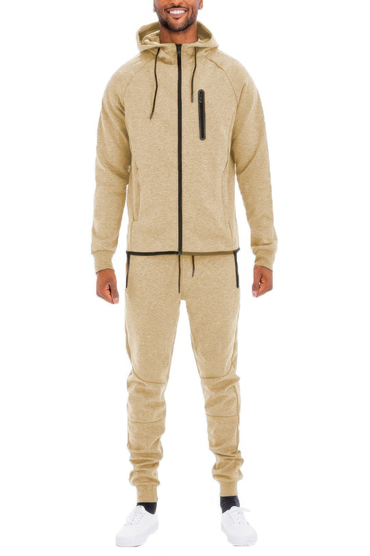Man wearing a beige tracksuit on a white background