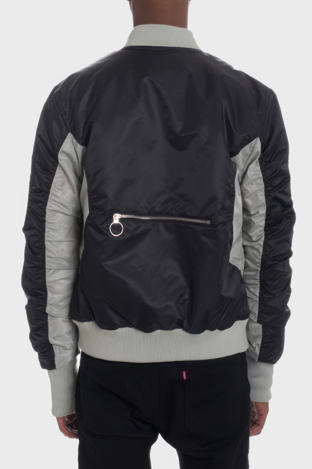 Person wearing a black and gray bomber jacket on a white background