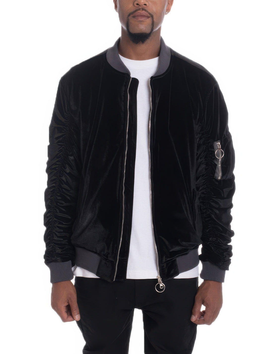 Man wearing a black bomber jacket with gray accents on a white background