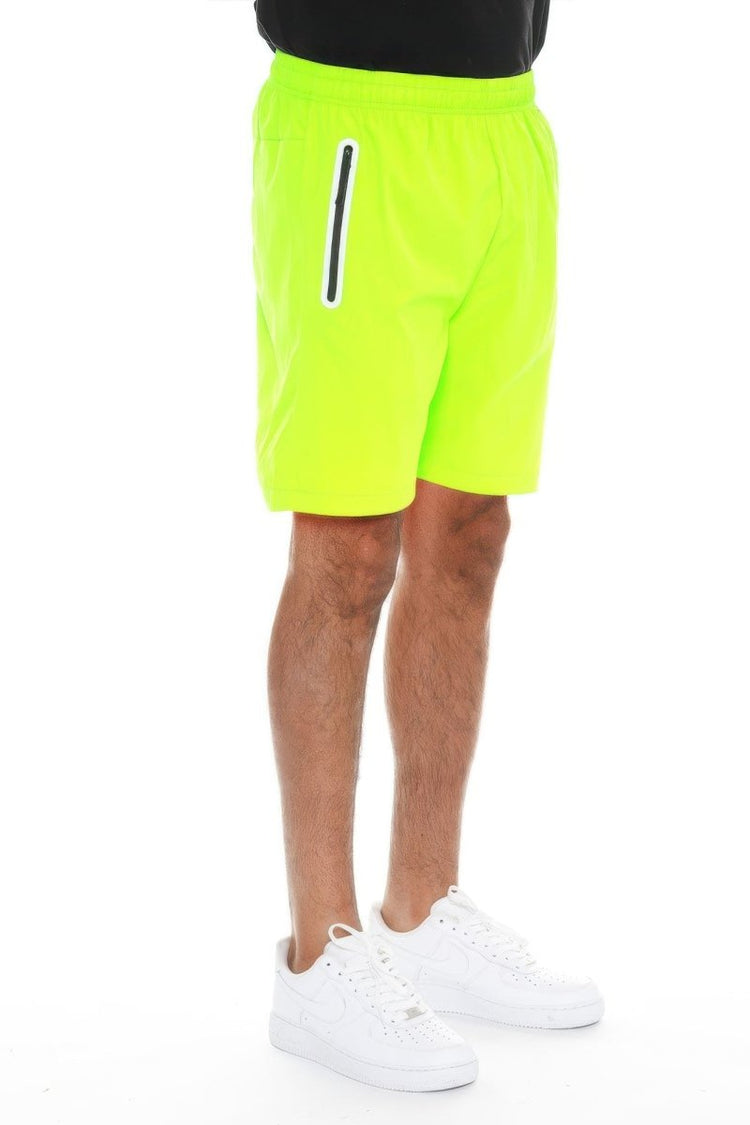 Person wearing bright yellow shorts with a white stripe on a white background