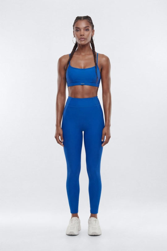 Woman wearing a blue athletic outfit on a white background