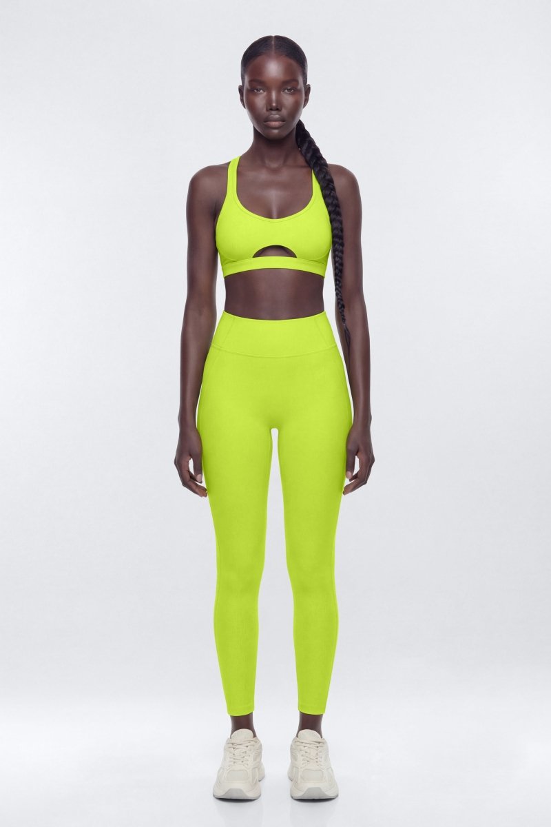Person wearing a bright green athletic outfit on a white background