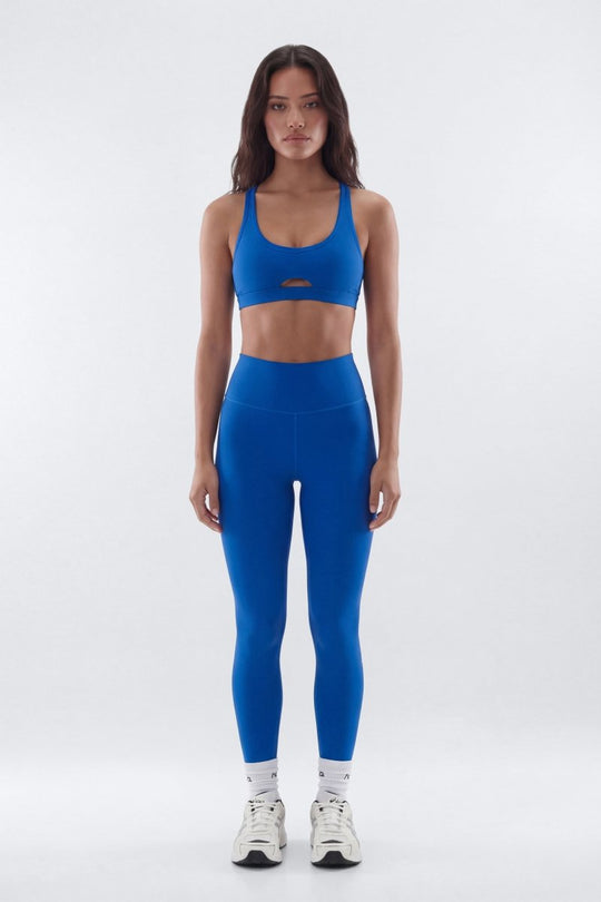 Woman wearing a blue athletic outfit on a white background