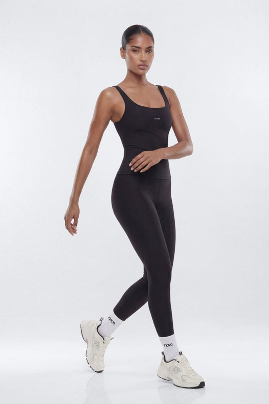 Woman wearing a black athletic outfit on a white background