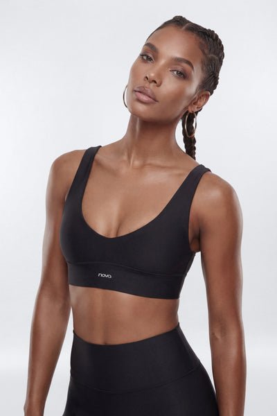 Woman wearing a black sports bra with a visible brand logo on a white background