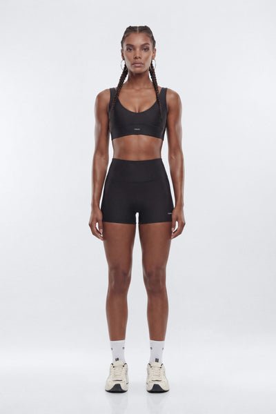 Woman wearing a black athletic outfit on a white background