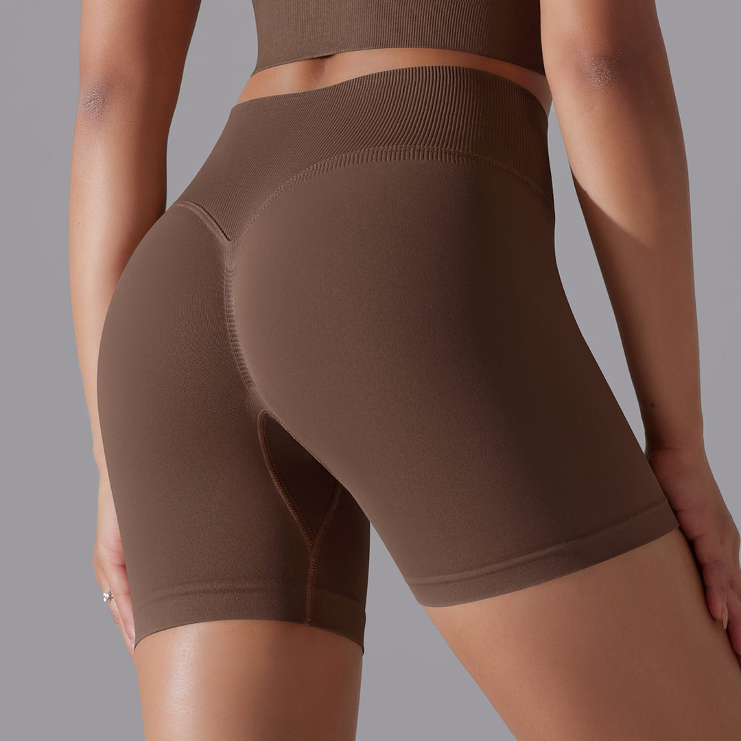 Brown athletic shorts worn by a person on a gray background