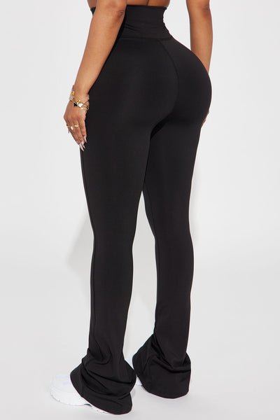 Black high-waisted pants worn by a person on a white background