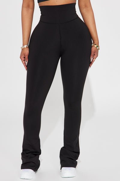 Person wearing black high-waisted pants on a white background