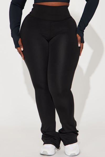 Black high-waisted leggings worn by a person on a white background