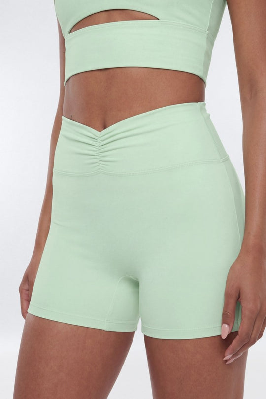 Light green athletic top and shorts set on a white background